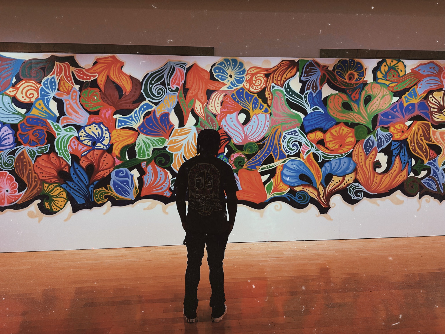 Young Moddy standing in front of a colorful mural